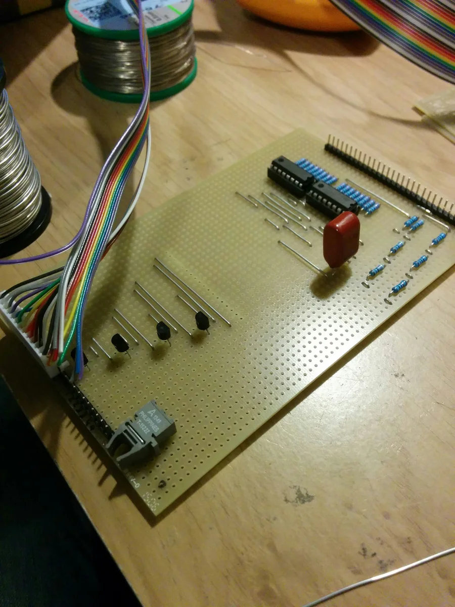 Stripboard with hand-soldered shift registers, resistors, and ribbon cable connector