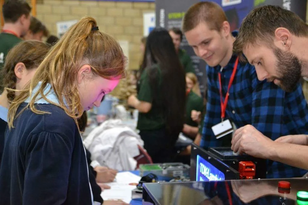 Student playing Simon Says while engineers assist at the Big Bang Fair booth